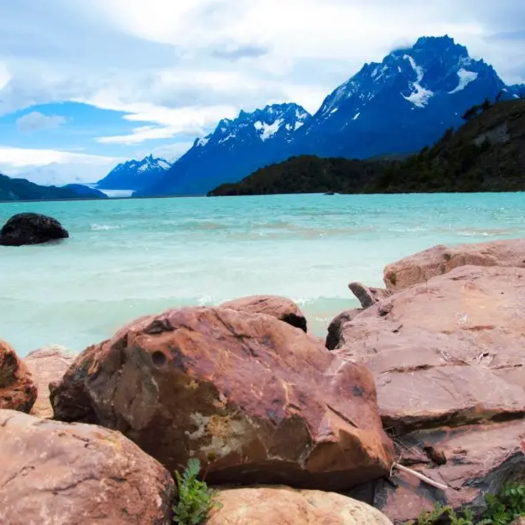 The Grey Lake mirrors the towering mountains and the glacier’s icy blue, creating a breathtaking Patagonian landscape.