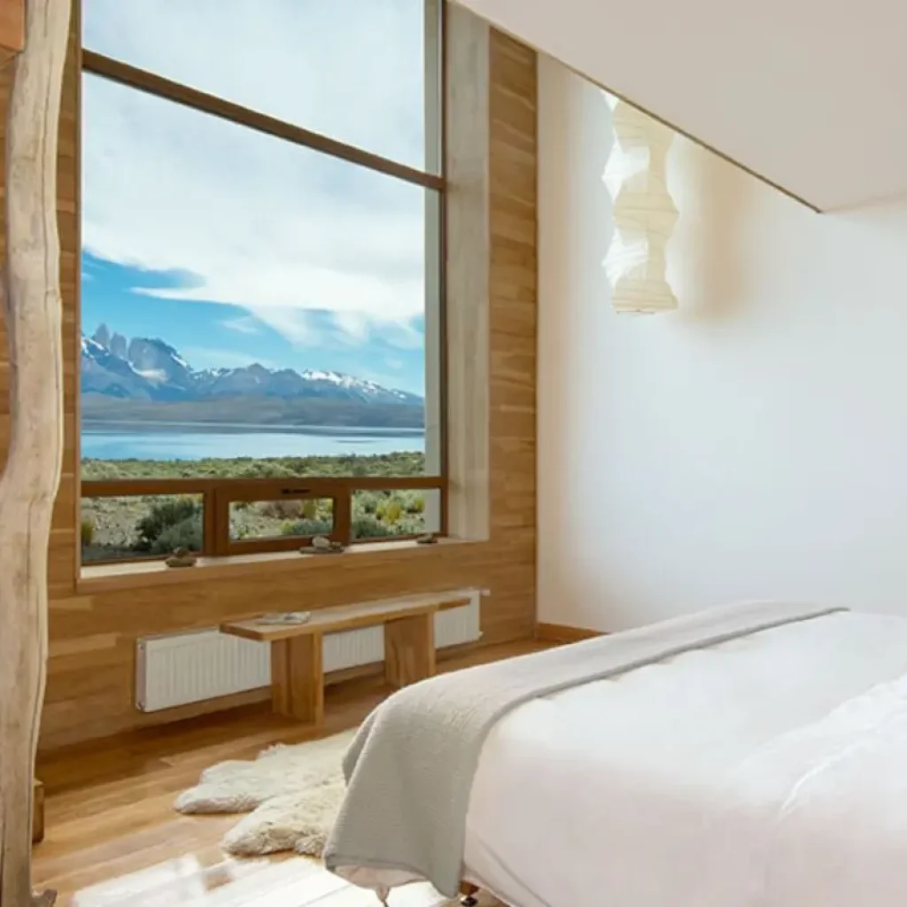 Elegante habitación con grandes ventanales que ofrecen vistas a las Torres del Paine.