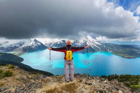 Un randonneur embrasse l'immense beauté du glacier et du lac Garibaldi depuis un point de vue parfait.