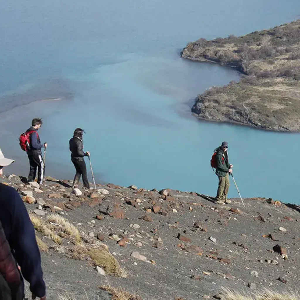 Aventureros haciendo senderismo, rodeados de imponentes montañas.