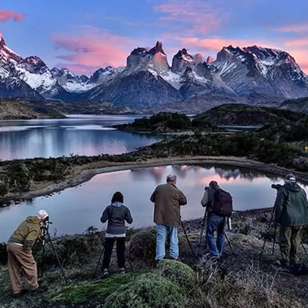 Los visitantes captan la serena belleza del lago y su paisaje con sus cámaras y trípodes.