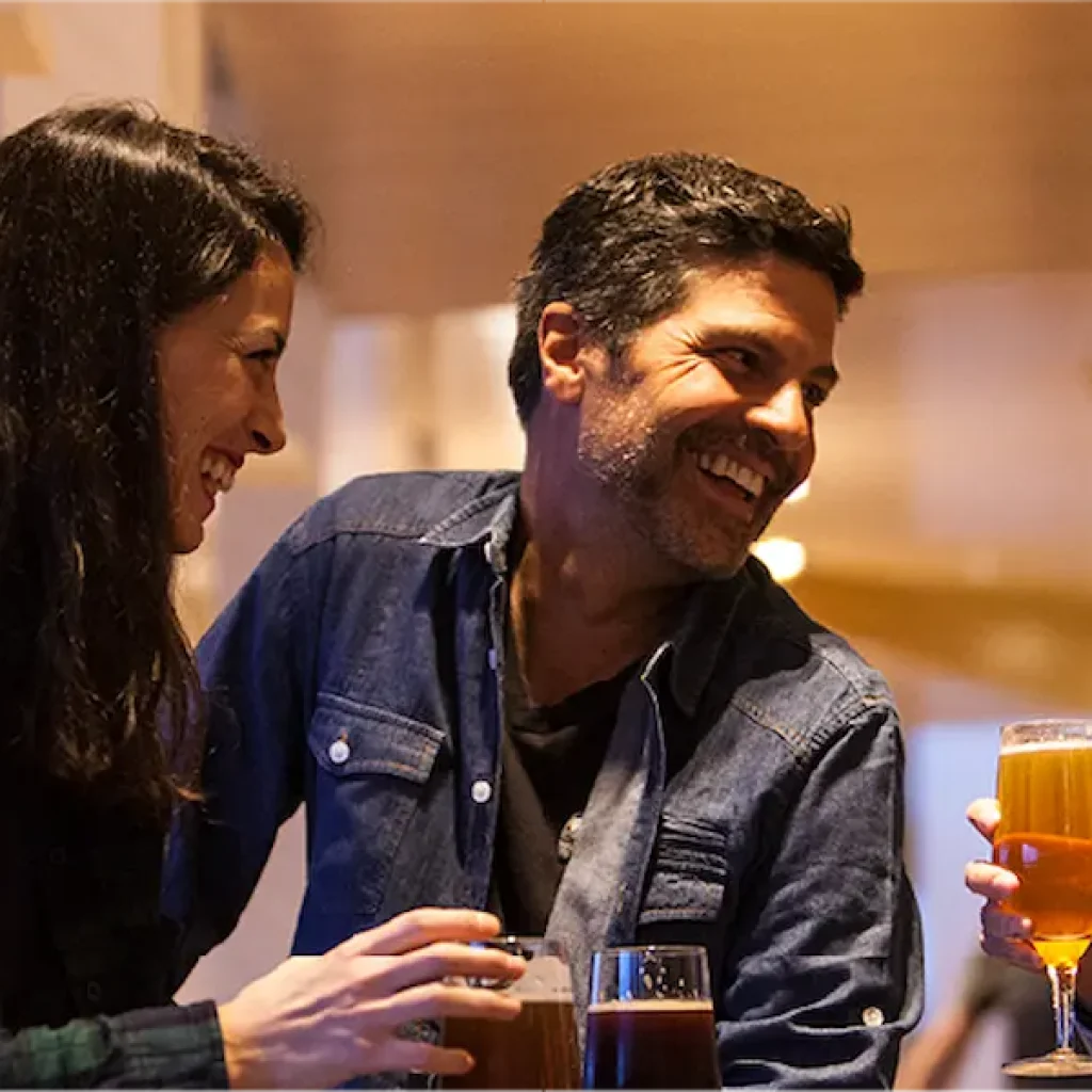 Un animado grupo de amigos disfruta de una alegre velada en el acogedor bar del hotel.