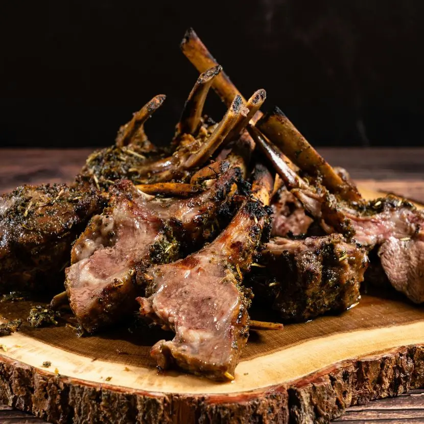 Costine di agnello della Patagonia arrostite a fuoco lento, condite con erbe selvatiche e cotte a fuoco aperto.