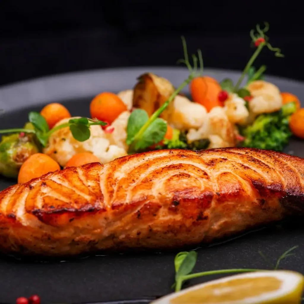 Filetto di salmone della Patagonia alla griglia abbinato a verdure di stagione ed erbe autoctone.