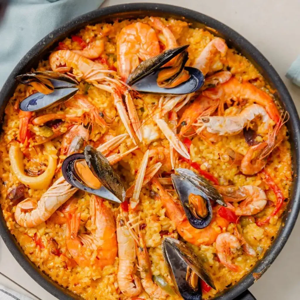 Paella di mare con gamberi, cozze e calamari della Patagonia, ricca di sapori oceanici.