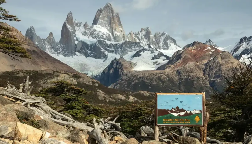 Cartello che indica il belvedere del Monte Fitz Roy a 750 metri sul livello del mare, con le cime granitiche innevate sullo sfondo, nei pressi di El Chaltén nel Parco Nazionale Los Glaciares