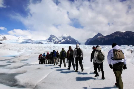 Group of trekkers with backpacks walking across the ice of the Perito Moreno Glacier, El Calafate, Patagonia, Argentina